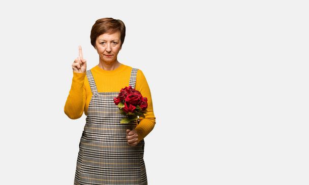 Middle aged woman celebrating valentines day showing number one - Photo, Image