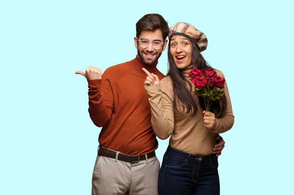 Young couple in valentines day pointing to the side with finger - Photo, Image