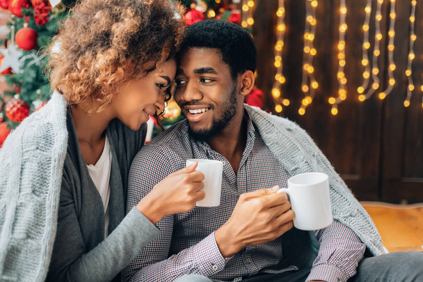 Νεαρό ζευγάρι πίνοντας τον καφέ και την απόλαυση των Χριστουγέννων το πρωί - Φωτογραφία, εικόνα