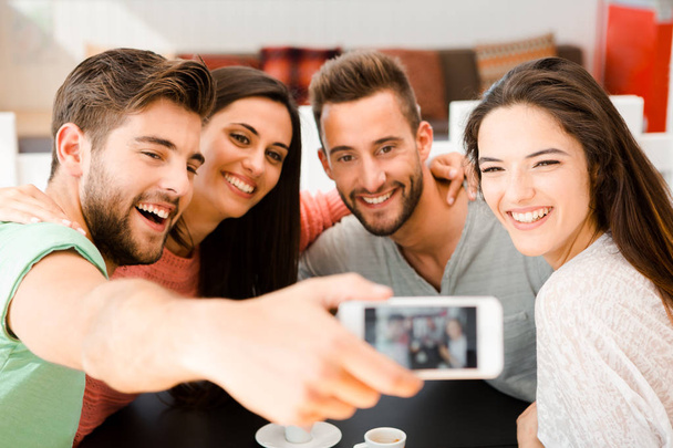 Group of friends at the coffee shop making a selfie together  - 写真・画像