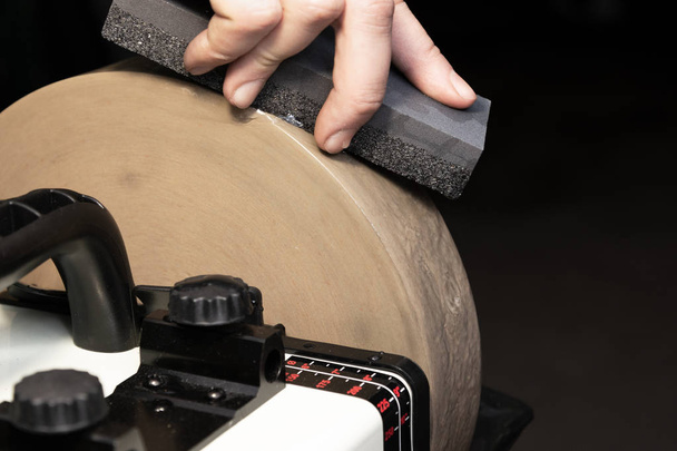 Вирівнювання шліфувального каменю лезом для загострення ножів
 - Фото, зображення