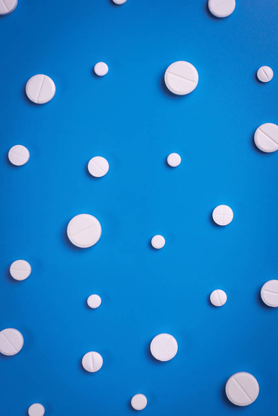 Pílulas de medicina farmacêutica, comprimidos em fundo azul. Espaço de cópia para texto
 - Foto, Imagem
