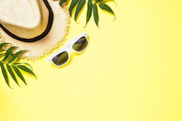 Summer hat and sunglasses on yellow top view. - Fotoğraf, Görsel