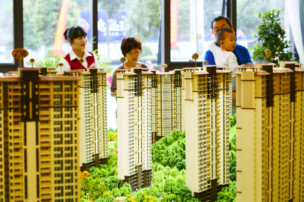 Chinese homebuyers look at housing models at the sales center of a residential property project in Yichang city, central China's Hubei province, 1 October 2015 - Foto, immagini