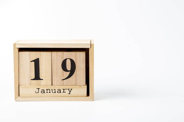 Calendario de madera 19 de enero sobre fondo blanco de cerca
 - Foto, imagen