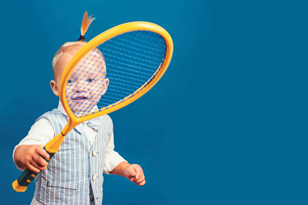 Cute and energetic. Little sport lover. Adorable little child with tennis racket. Active happy child. Small tennis player. Enjoying my favorite sport, copy space - Zdjęcie, obraz