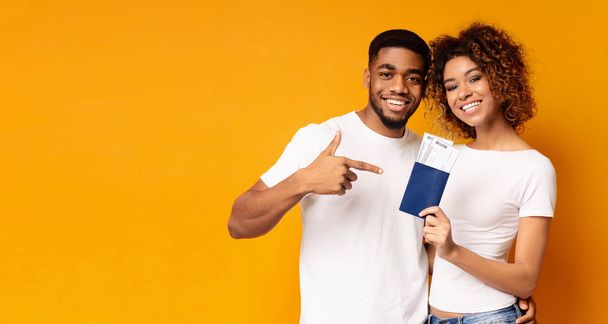 パスポートとチケットを保持している幸せな若い黒人カップル - 写真・画像