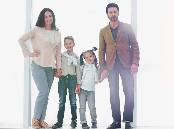 portrait of a modern family standing near a large window - Photo, image