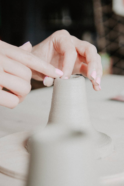 Creating a jar or vase of white clay close-up. Woman hands making clay jug. - Fotoğraf, Görsel