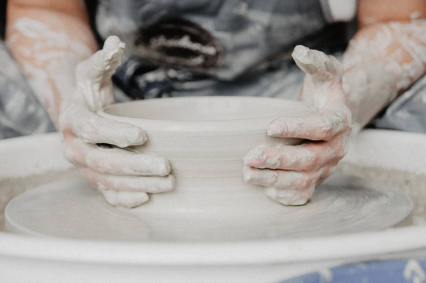 Creating a jar or vase of white clay close-up. Woman hands making clay jug. - Foto, imagen
