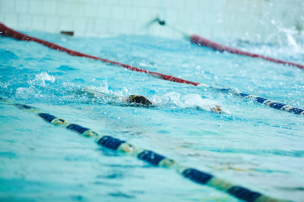 Παιδιά κολύμβησης freestyle στο μάθημα κολύμβησης. Παιδιά του δημοτικού σχολείου σε κοντινή δεξιότητες μάθημα. Παιδιά σχολικής ηλικίας μαθαίνουν να κολυμπούν. ΠΑΙΔΙΚΟΙ Κολυμβητικοι ανταγωνισμό στην εσωτερική πισίνα - Φωτογραφία, εικόνα