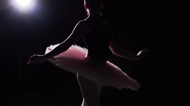 Slow motion shot of ballerina dancing in studio. Beautiful female ballet dancer on a black background. Ballerina wearing tutu and pointe shoes. Slow motion. - Filmagem, Vídeo