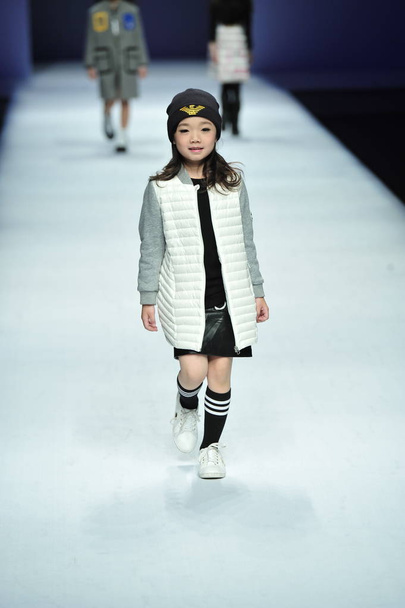 A child model displays a new creation at the fashion show of Tingzu during the China Fashion Week Fall/Winter 2016 in Beijing, China, 27 March 2016. - Foto, afbeelding