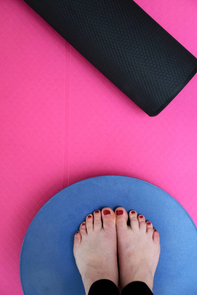 Вправа з балансовою дошкою, пінним валиком і рожевим килимком йоги
 - Фото, зображення