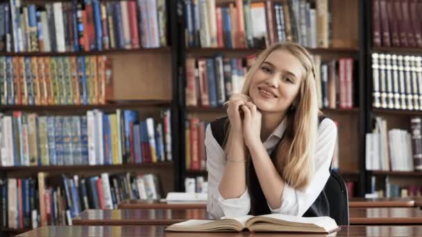 Gyönyörű lány hallgató olvasó egy könyv-tár - Felvétel, videó