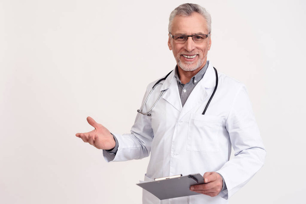 Portrait of smiling doctor with stethoscope and clipboard isolated. - Foto, Imagen