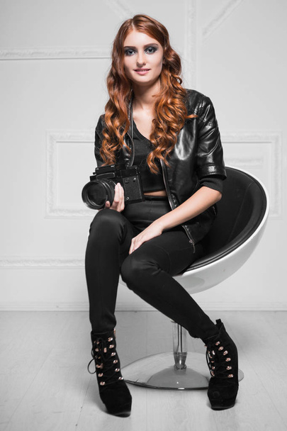 Alluring red-haired woman wearing black clothes and posing at camera - Fotoğraf, Görsel