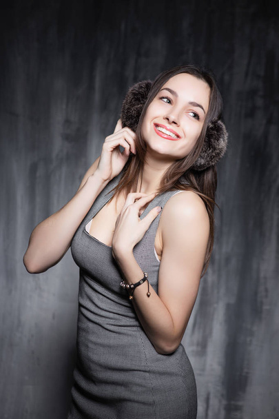 portrait of young woman in grey dress posing in studio - Photo, Image