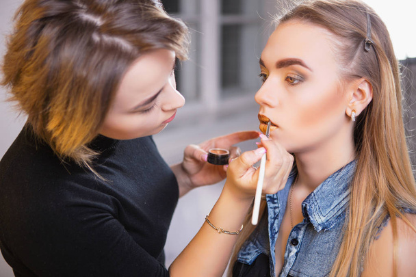 Makeup artist doing make up to young beautiful model - Фото, изображение