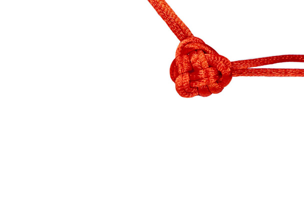 Small red valentine knot made from decorative cord. Macrame. - Foto, afbeelding