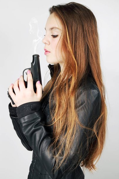 girl blows to the smoke in the pistol - Fotografie, Obrázek