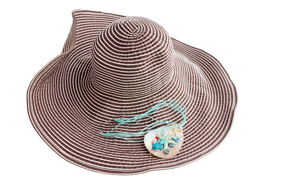 капелюх з сонцезахисними окулярами та ювелірними виробами підвіски
 - Фото, зображення