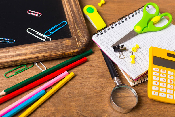 Notebook with school supplies on a wooden background - Foto, immagini