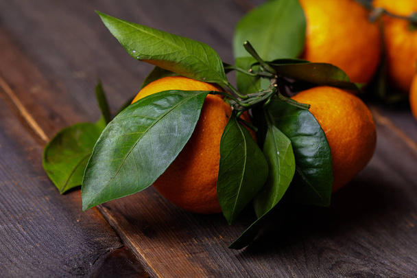 tangerines with leaves on pine boards - Foto, afbeelding