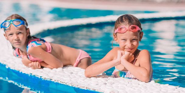 Adorable little girls in outdoor swimming pool - Zdjęcie, obraz
