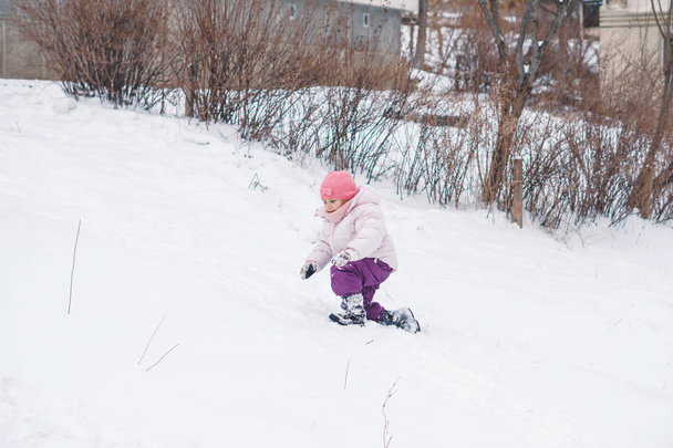 girl playing in snow at yard - Fotoğraf, Görsel