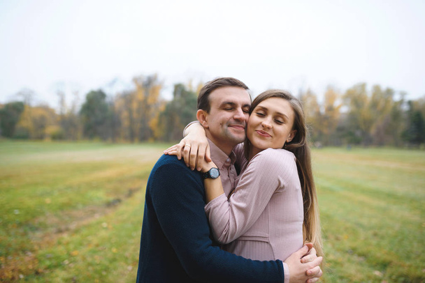woman and loving man outdoors in park, couple hugging  - Photo, Image