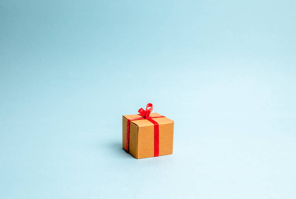 Gift box on blue background. Minimalism. The approach of the New Year holidays or birthday. Sale of gifts, special promotion, marketing and advertising. Donation concept. - Fotoğraf, Görsel