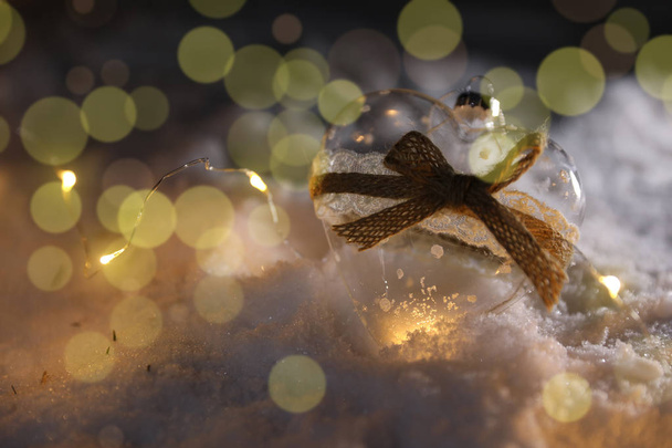 Glass heart and Christmas lights on snow against blurred background, space for text. Winter decor - Foto, immagini