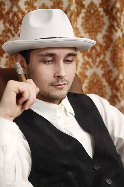 A pensive man in a hat with a cigar - 写真・画像