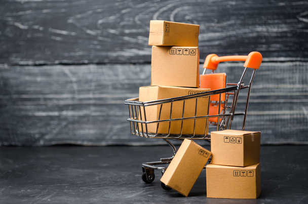 A supermarket cart loaded with cardboard boxes. Sales of goods. concept of trade and commerce, online shopping. high. delivery order. purchasing power of the population and the state of the economy - 写真・画像