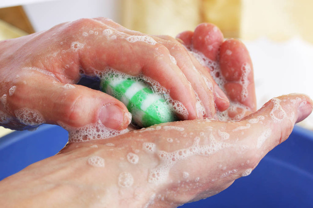 男は、緑色の石鹸で手を洗う - 写真・画像
