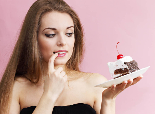 Beautiful woman holding a piece of chocolate cake - Фото, изображение