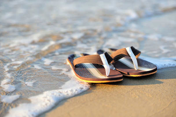 Flip flops on a sandy ocean beach - Photo, Image