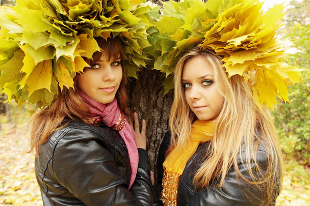 jonge dames dragen een krans van de herfst bladeren - Foto, afbeelding