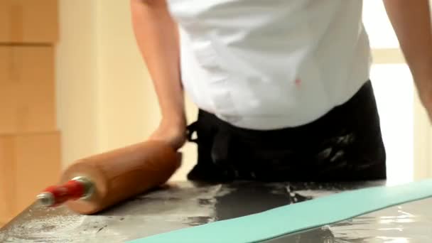 Confiseur utilisant le rouleau à pâtisserie préparant le fondant pour la décoration du gâteau
. - Séquence, vidéo