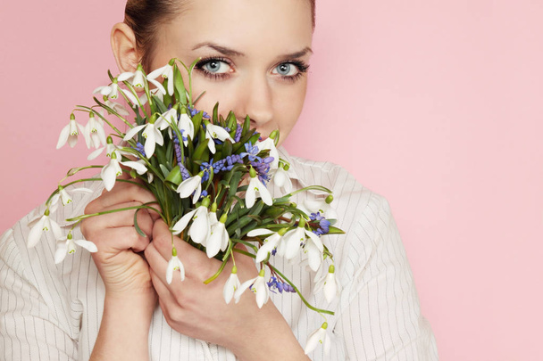 Snowdrops の花束を保持している若い美しい女性 - 写真・画像