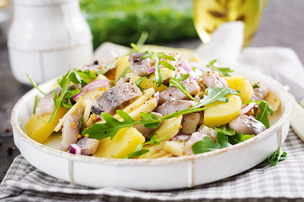 Traditionele salade van gezouten haring filets, rode ui en verse appels en aardappelen. Koosjer eten. Scandinavische keuken. - Foto, afbeelding