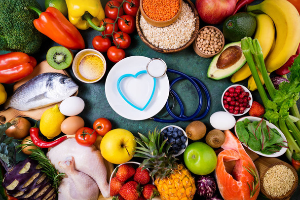 Terveellistä ruokaa terveelle sydämelle. Tuoreet hedelmät, vihannekset, kala, liha, marjat ja viljat. Terveellinen ruoka, ruokavalio, lääketiede ja terveellisen elämän käsite. Ylänäkymä, kopioi roskaposti
 - Valokuva, kuva