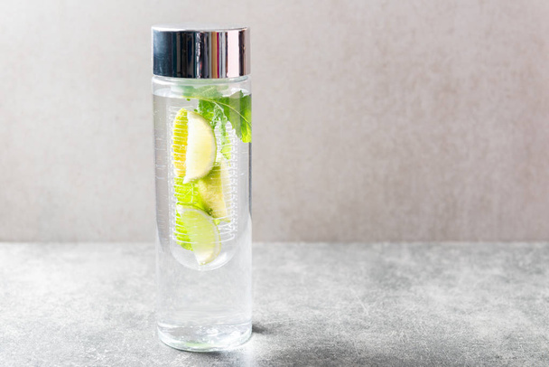 Αρωματισμένο νερό με λάιμ και μέντα σε ειδικό μπουκάλι. Υγιεινή διατροφή δίαιτα έννοια - Φωτογραφία, εικόνα