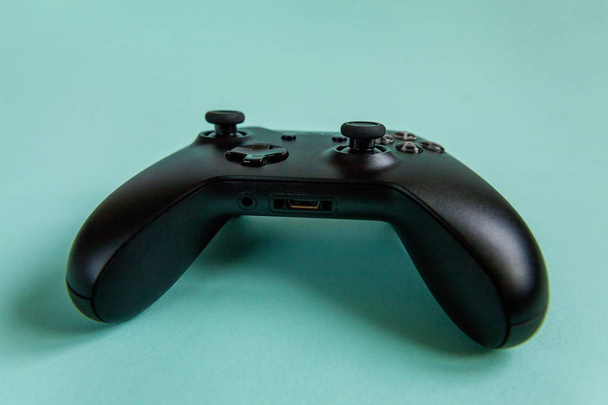 Joystick preto gamepad, console de jogo em azul colorido moderno moda pin-up fundo. Concorrência de jogos de computador conceito de confronto de controle de videogame. Símbolo ciberespaço
 - Foto, Imagem