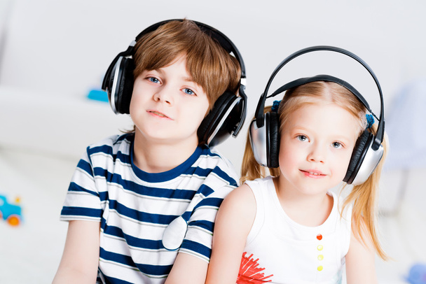 Brother and sister listening music with headphones - Foto, Imagen