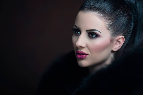 Portrait of a pretty girl with a black fur  - Foto, imagen