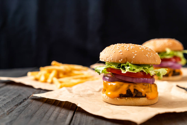 fresh tasty beef burger with cheese and french fries on wood background - Fotografie, Obrázek