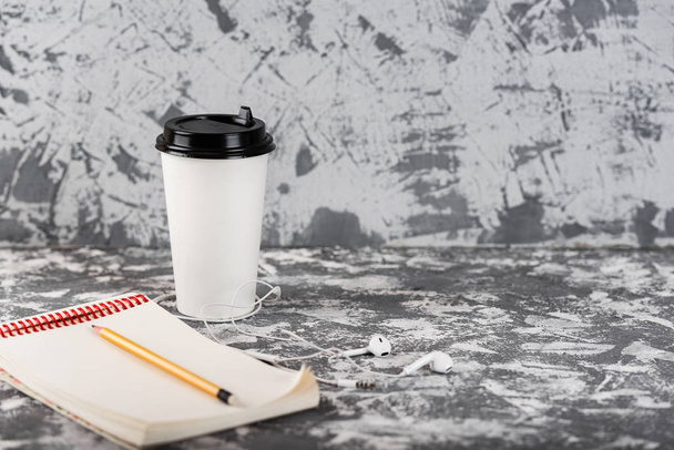 Working on the go. Coffee cup and notepad on grey stone table. Copy space - Foto, Bild