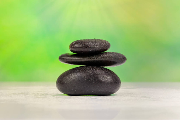 balancierte Zen-Steine mit Wassertropfen auf grünem Bokeh-Hintergrund - Foto, Bild